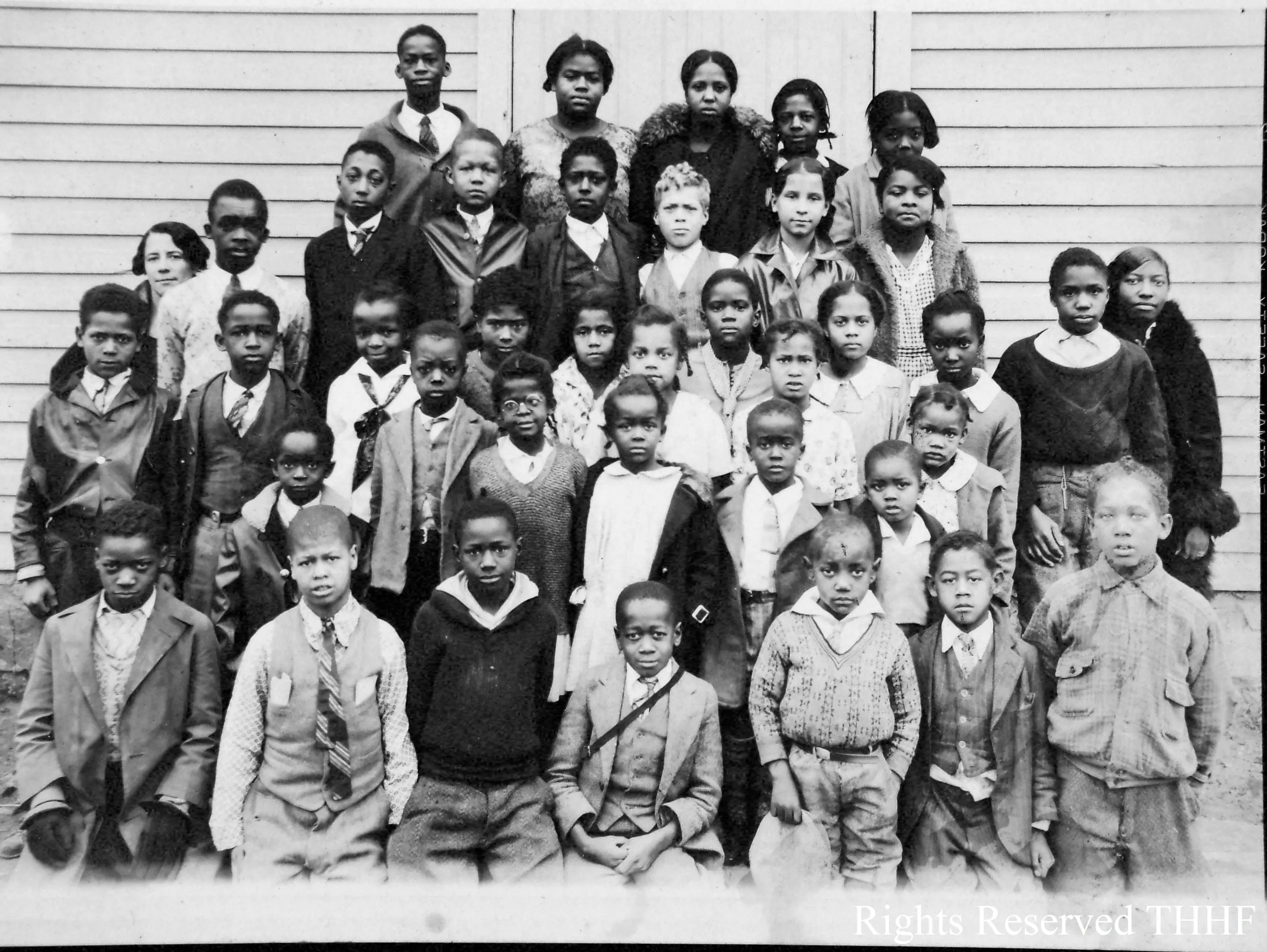 Mary Ellen Henderson y sus estudiantes frente a la escuela de color James Lee